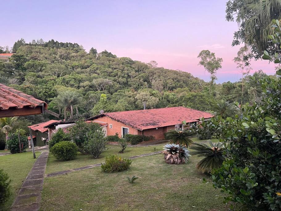 una casa con techo rojo frente a una montaña en Chácara condomínio Porta do Sol en Mairinque