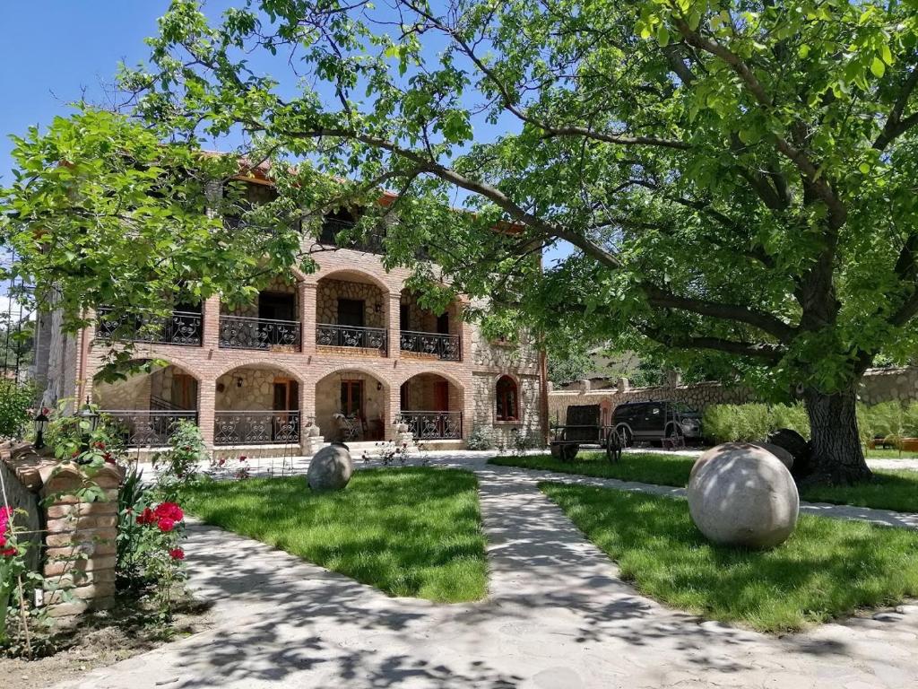 a large house with a tree and a driveway at Château Fort de Manavi, Boutique Hotel in Manavi