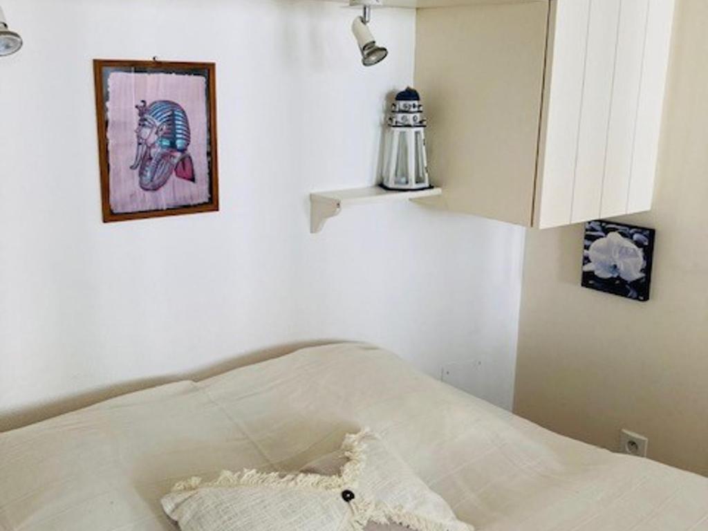 a white bed in a room with a picture on the wall at Studio Saint-Martin-de-Ré, 2 pièces, 4 personnes - FR-1-544-25 in Saint-Martin-de-Ré