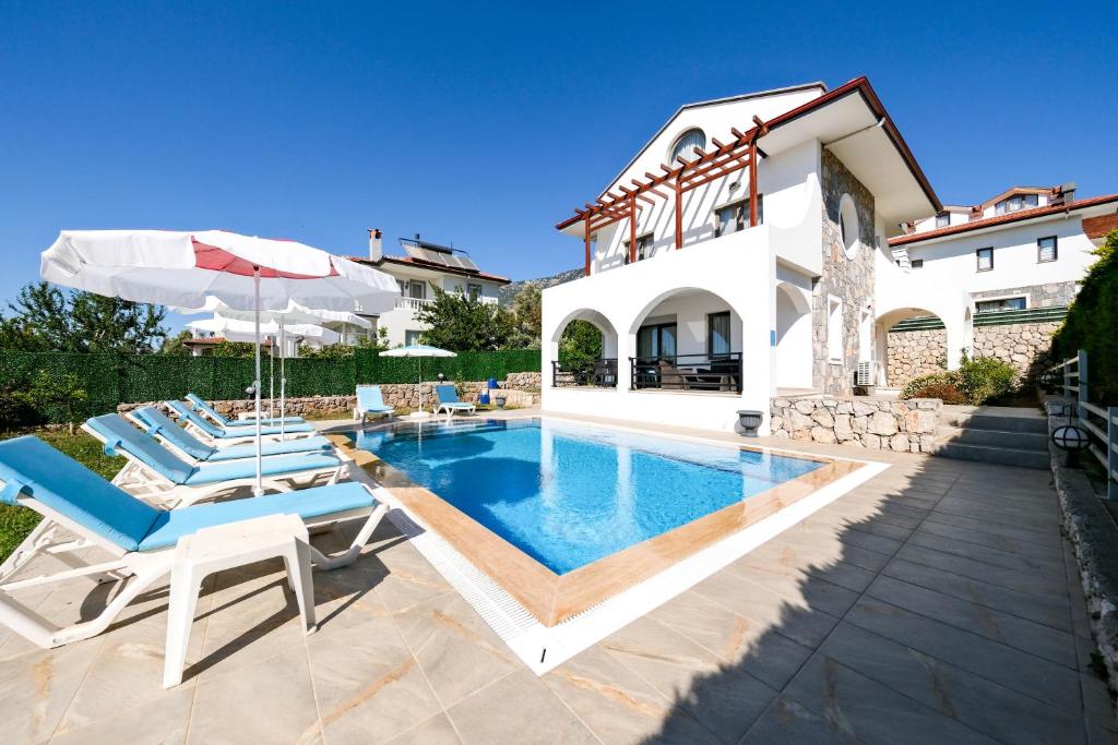 a villa with a swimming pool and a house at Turquoise Shores Family-Friendly Luxury Villa Fethiye Oludeniz by Sunworld Villas in Fethiye