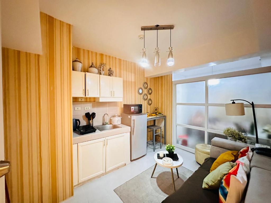 a living room with a couch and a kitchen at Tagaytay Staycation - Casa Editha in Tagaytay