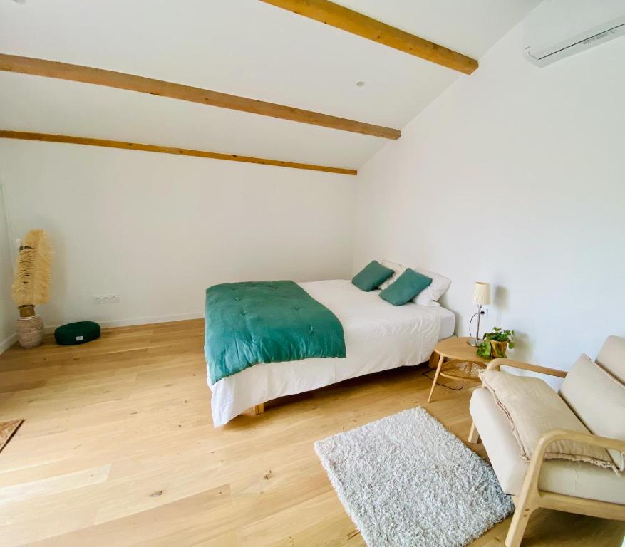 ein weißes Schlafzimmer mit einem Bett und einem Sofa in der Unterkunft Chambre l&#39;Aqueduc in Castries