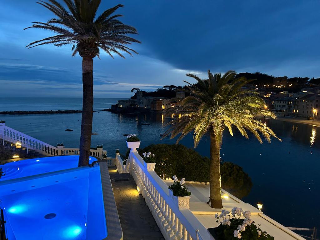 a view of a balcony with palm trees and the water at Hotel Helvetia in Sestri Levante