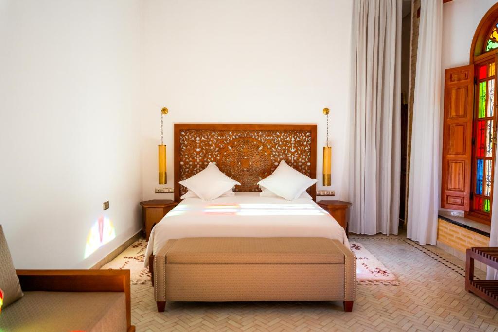 a bedroom with a bed and a couch at Riad Al Ansari in Fez