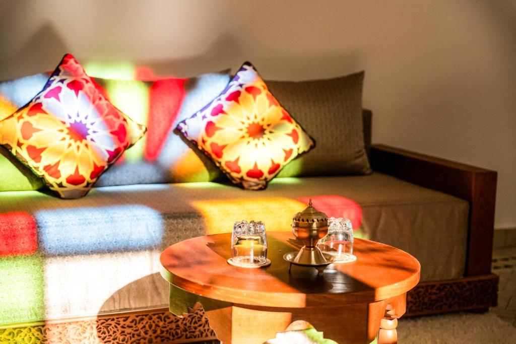 a living room with a couch with pillows and a table at Riad Al Ansari in Fez