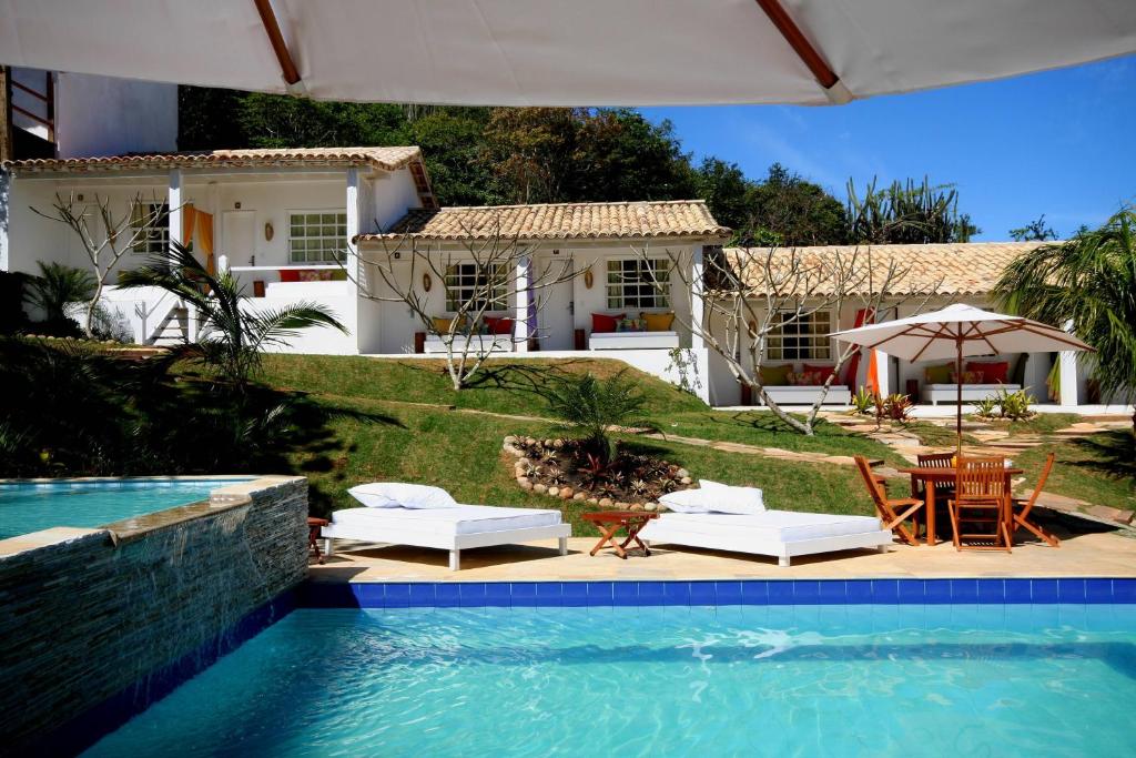 une villa avec une piscine et une maison dans l'établissement Pousada Bucaneiro, à Búzios