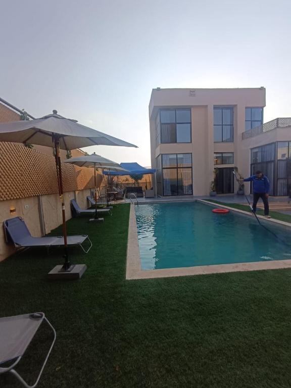 Un uomo sta saltando in una piscina di Airport house ad Amman