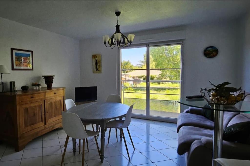 une cuisine et une salle à manger avec une table et des chaises dans l'établissement Appartement solaire duplex avec terrasse en bois, à Pessac