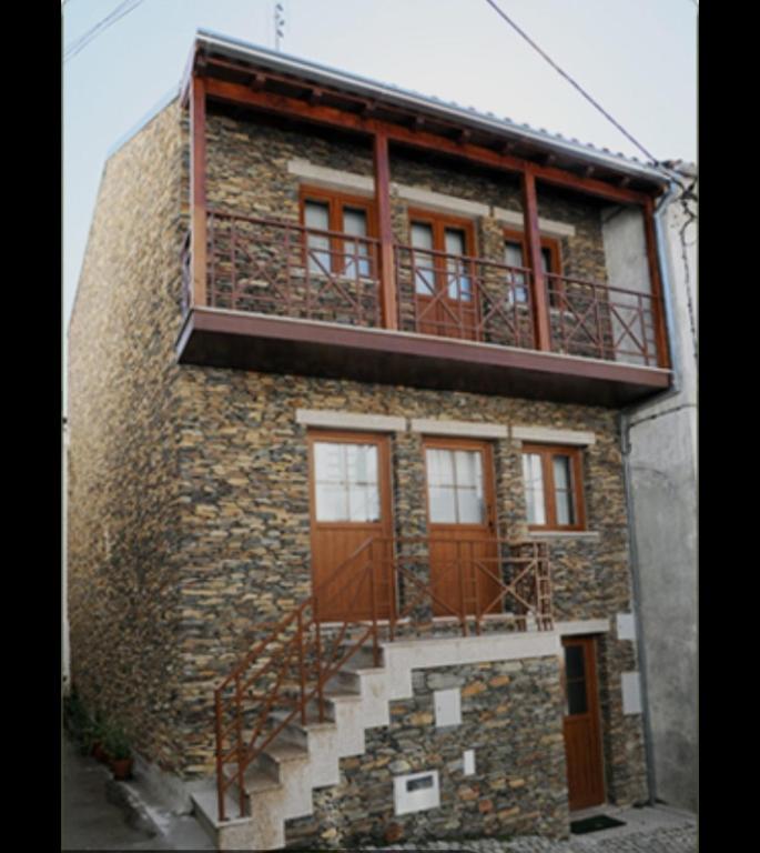 a brick building with a balcony on top of it at Latada Suit's Serra da Estrela in Sameiro