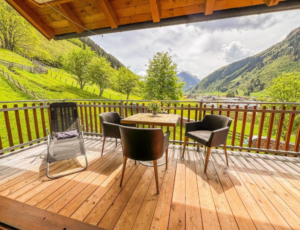 a wooden deck with a table and chairs on it at Modern Mountain Apart 5 - an der Skipiste in Rauris