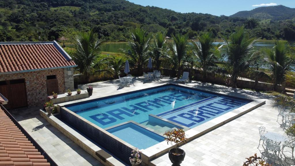 an overhead view of a swimming pool with palm trees and a house at Pousada de Campo Estância Bahamas in Pirenópolis