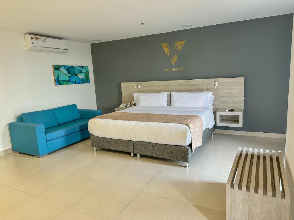 1 dormitorio con 1 cama y 1 sofá azul en VVC Hotel's, en Villavicencio