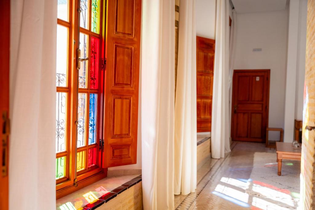 a hallway with stained glass doors in a house at Riad Al Ansari in Fez