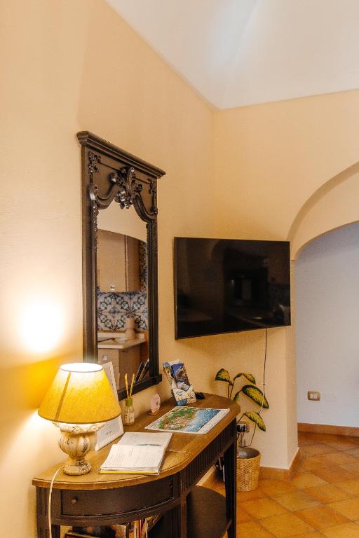 Pokój ze stołem z lampką i lustrem w obiekcie Casa Giulia - sophisticated apartment with view w mieście Positano
