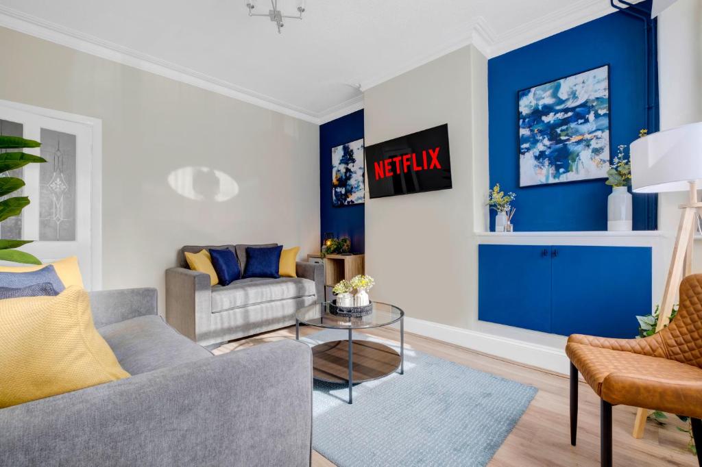 ein Wohnzimmer mit einer Wand mit blauen Akzenten in der Unterkunft Inspira Stays - Monthly DISCOUNTS - Stylish Modern 2 Bedroom House - Free Parking - Wi-Fi in Leicester