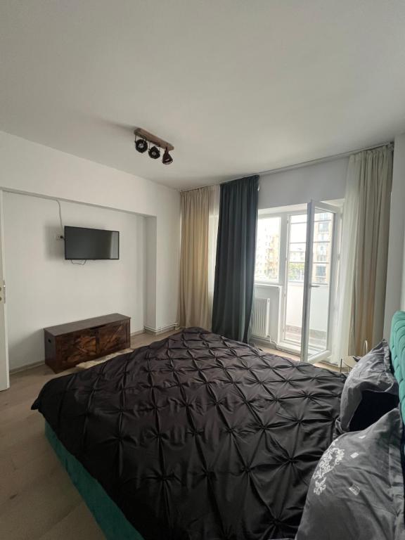 a bedroom with a large bed and a television at Rosa Apartment in Drobeta-Turnu Severin