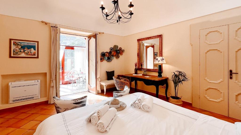 sypialnia z łóżkiem, biurkiem i lustrem w obiekcie Casa Giulia - sophisticated apartment with view w mieście Positano