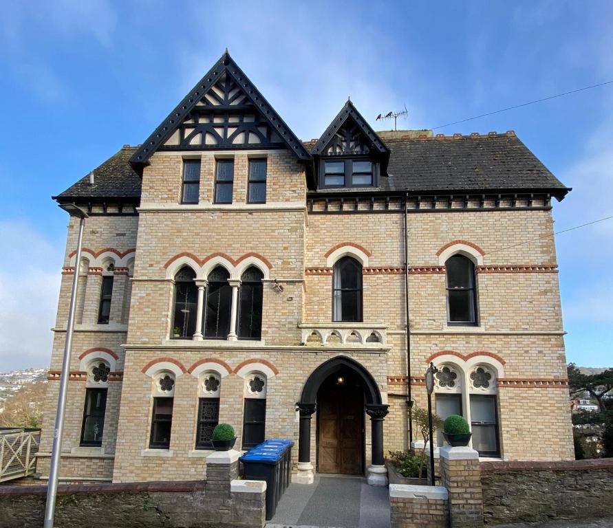 een groot bakstenen gebouw met een zwart dak bij The Regency in Ilfracombe