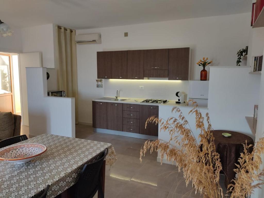 a kitchen with a table and a counter top at Casa Ciclamino in San Vito lo Capo