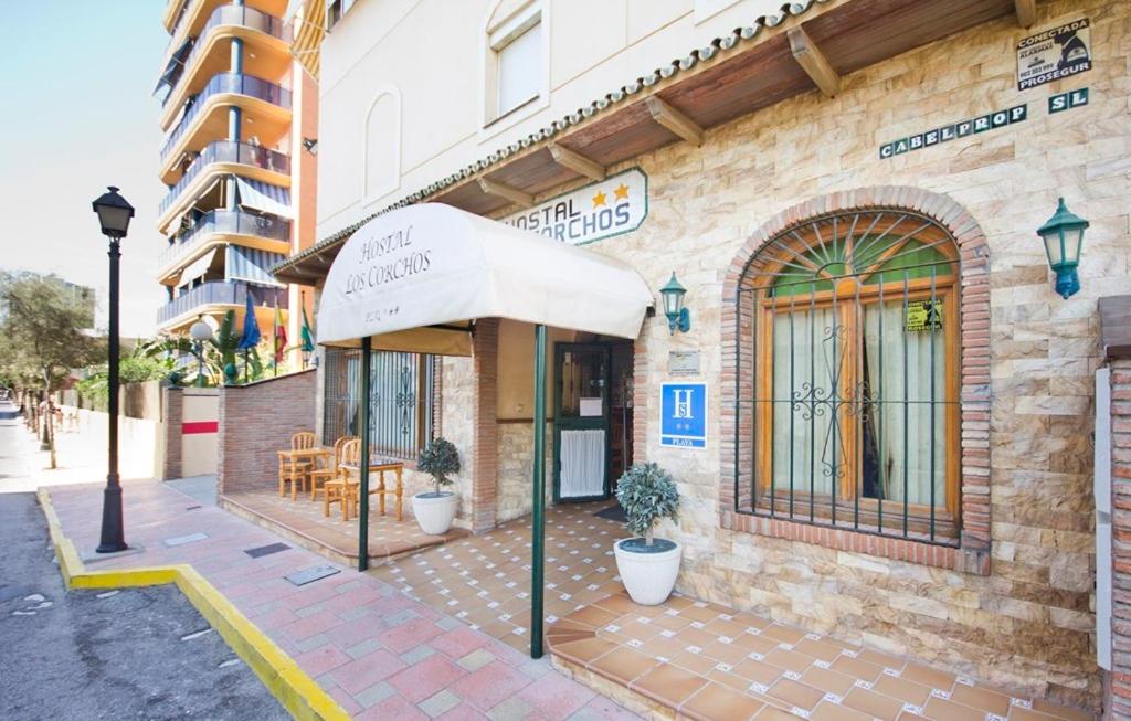 un edificio con un toldo al lado de una calle en Hostal Los Corchos, en Fuengirola