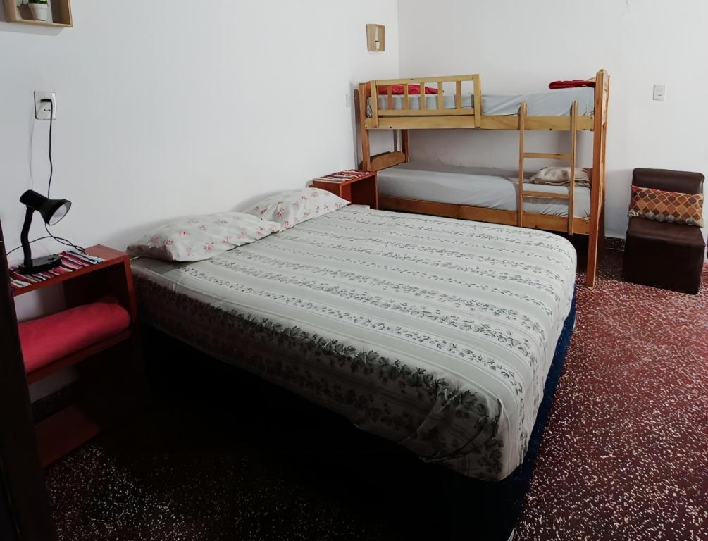 1 dormitorio con 1 cama y 1 litera en Jasy Hospedaje en Paraguarí