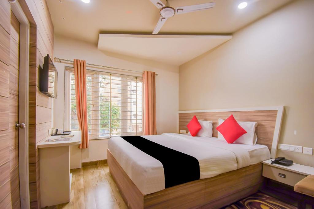 a bedroom with a large bed with red pillows at Super Collection O 75732 Hotel Aatithya in Bhubaneshwar
