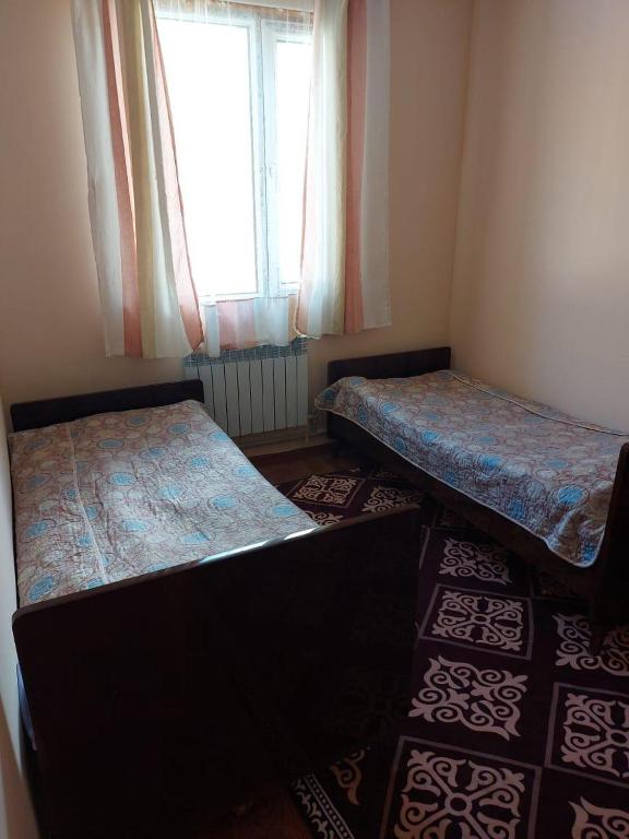 a small room with two beds and a window at Зона отдыха Махат in Kurmenty