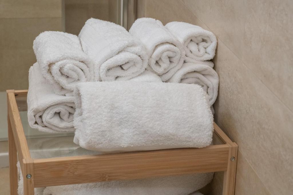stos ręczników na półce w łazience w obiekcie Villa Cristina B&b Alezio w mieście Alezio