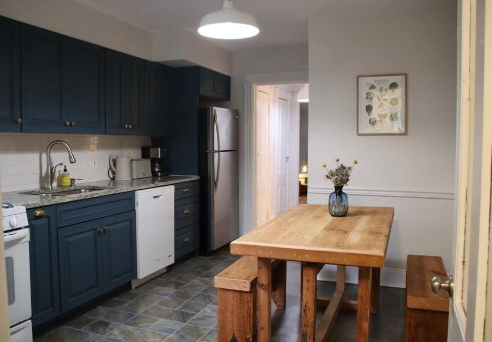 a kitchen with blue cabinets and a wooden table at Cosy apartment in Cobble Hill in Brooklyn