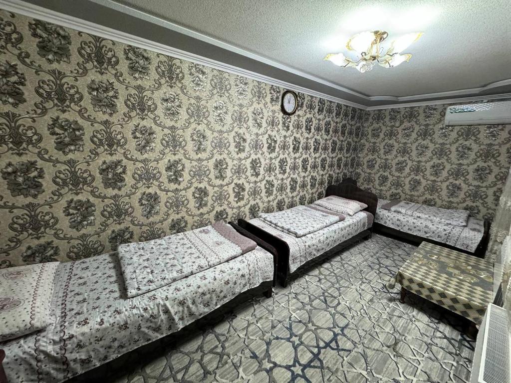 dwa łóżka w pokoju z tapetą w obiekcie BARNO 