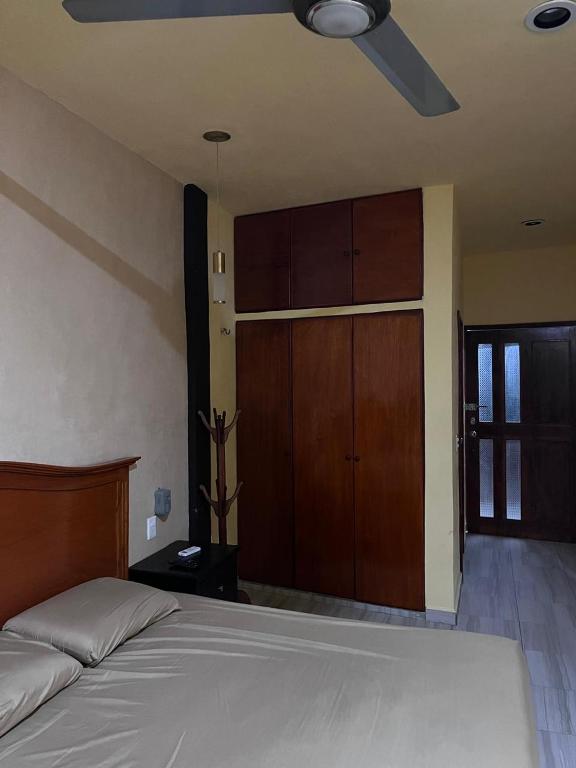 - une chambre avec un lit et un ventilateur de plafond dans l'établissement Grupo Kan, à Valladolid