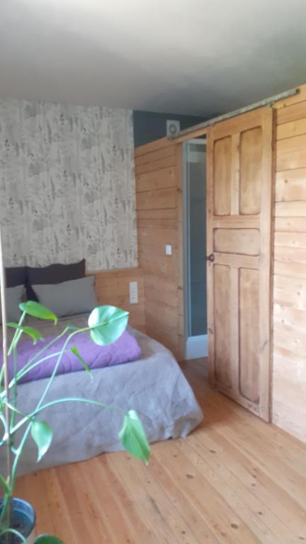 une chambre avec un lit et un parquet dans l'établissement Studio 20mn Puy du fou et Hellfest, à Le Longeron