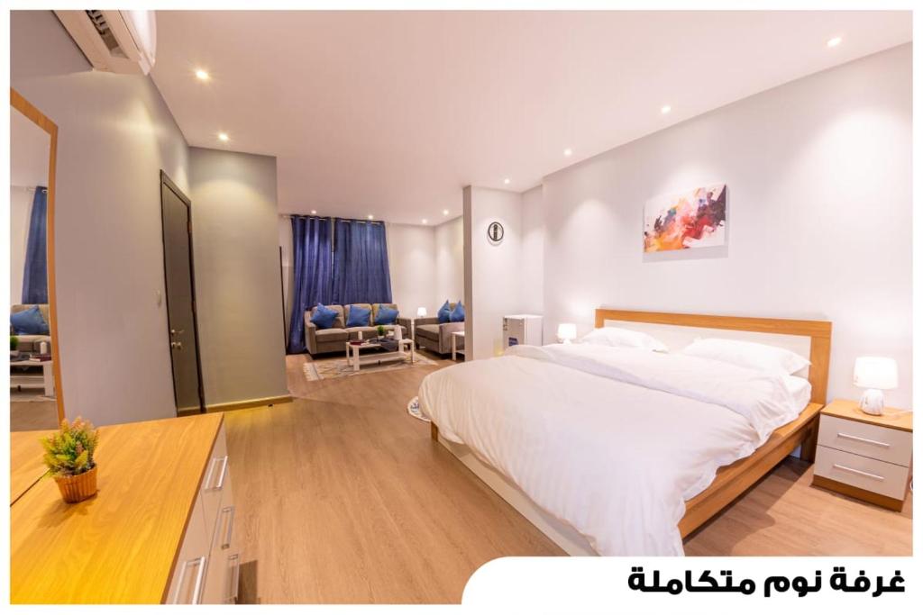 um quarto com uma grande cama branca num quarto em شقق فاخرة في برج المسارات em Ash Shati