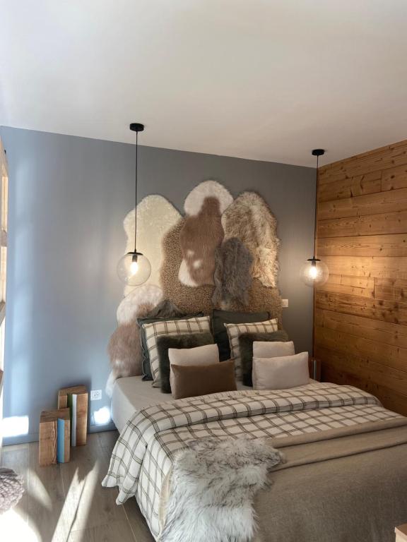 1 dormitorio con 1 cama con animales de peluche en la pared en Les vignes du château 2, en Chorges