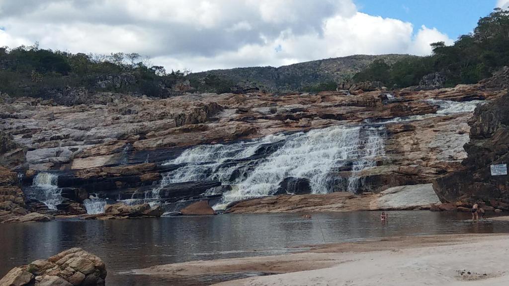 una cascata sul fianco di una scogliera rocciosa di Maria Bonita Eco Pousada a Diamantina