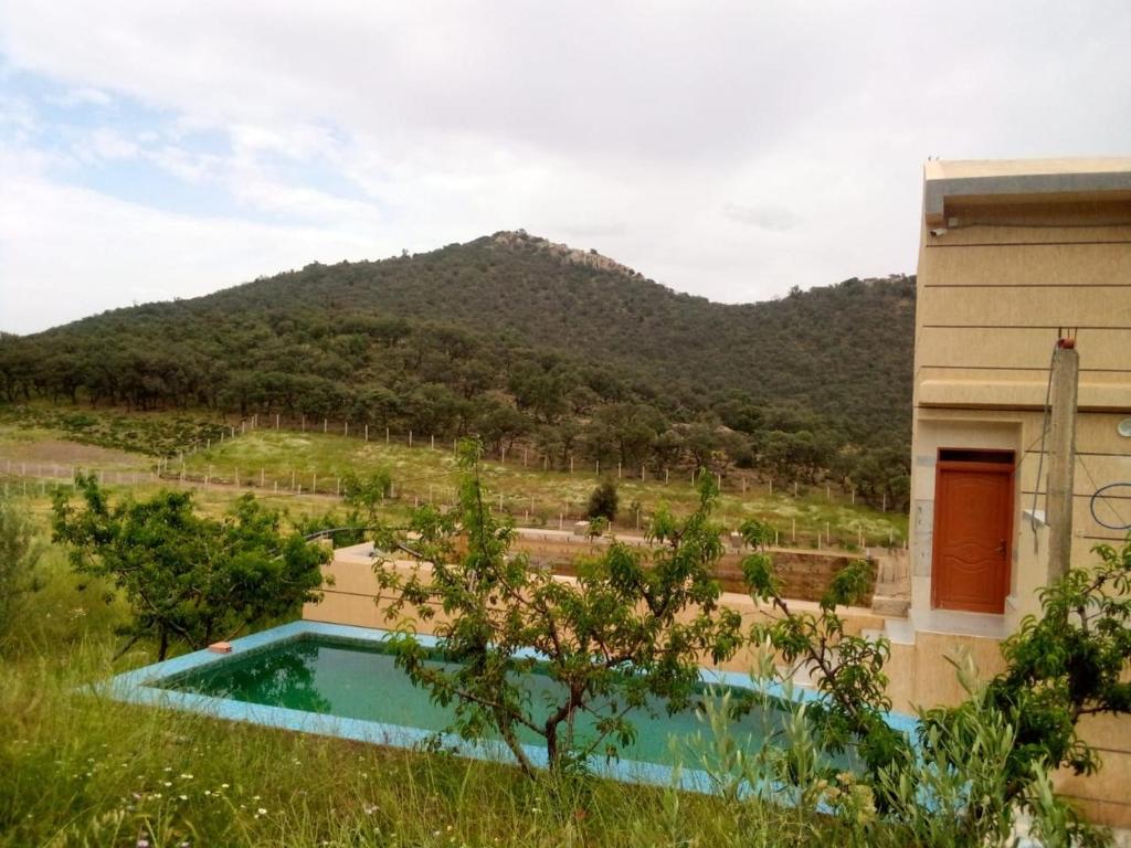ein Pool vor einem Haus mit einem Berg in der Unterkunft Gite Aguelmous réservé aux familles 