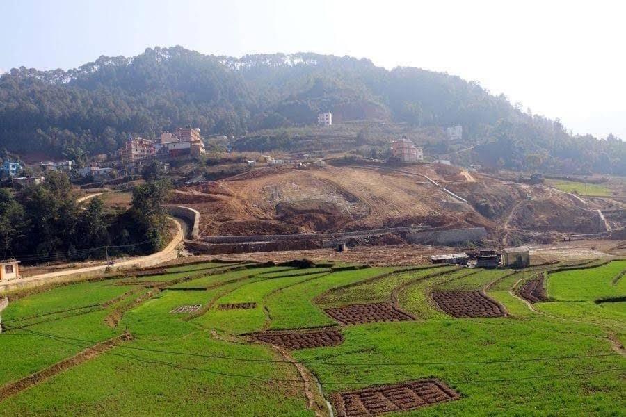 LalitpurにあるGodamchaur Villaの山を背景に広がる野原