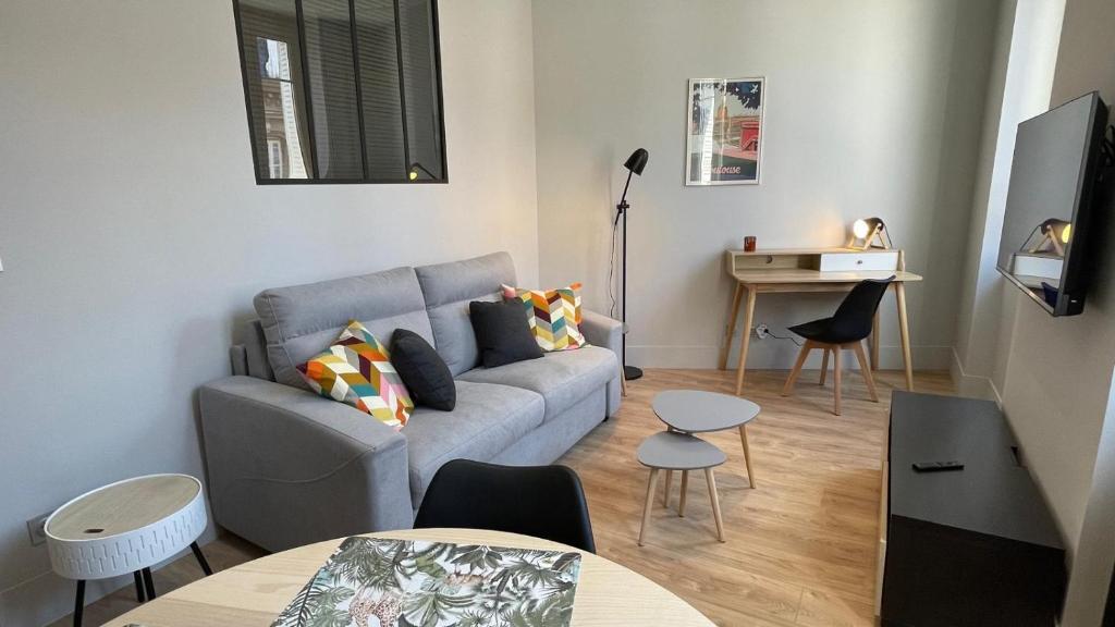 un salon avec un canapé et une table dans l'établissement Sublime T2, entièrement rénové, à Toulouse