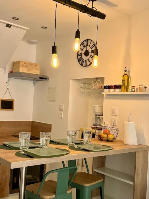 a kitchen with a table with two chairs and lights at Charmante maison de village in Peyriac-de-Mer