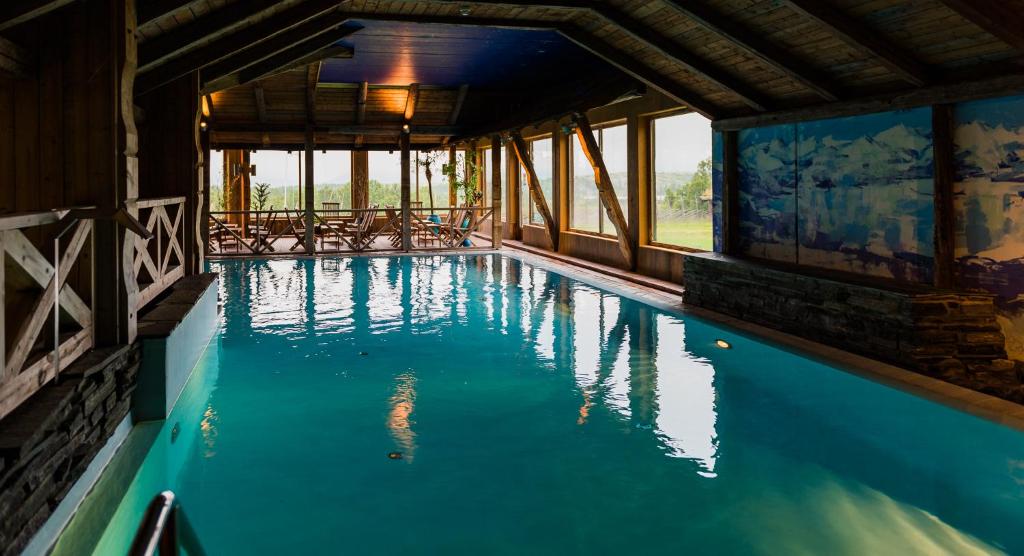 a swimming pool with blue water in a building at Spidsbergseter Resort Rondane in Venabygd