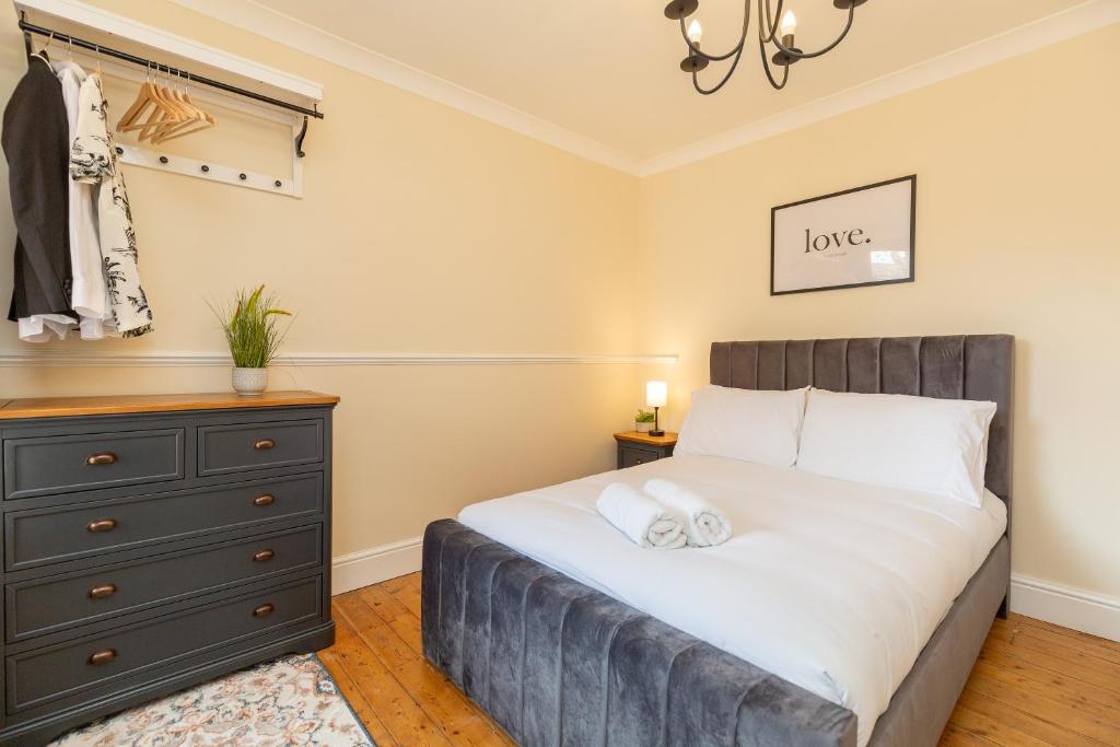 een slaapkamer met een groot bed en een dressoir bij Three Bedroom Apartment - Contractors & Groups welcome in Northampton by Centro Stays - Free WiFi & Parking in Northampton