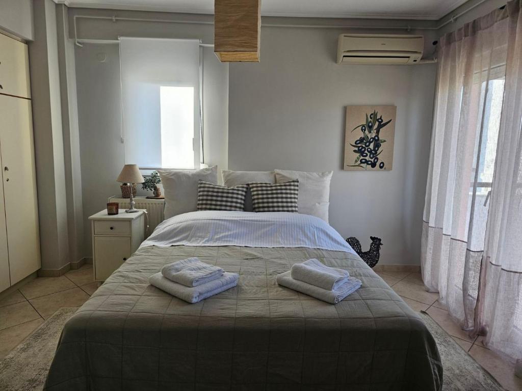 a bedroom with a large bed with two towels on it at Rooftops in Kavala