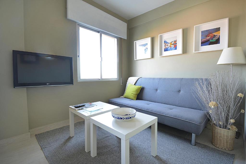 Apartamento con parking en San Vicente في او غروف: غرفة معيشة مع أريكة زرقاء وطاولة