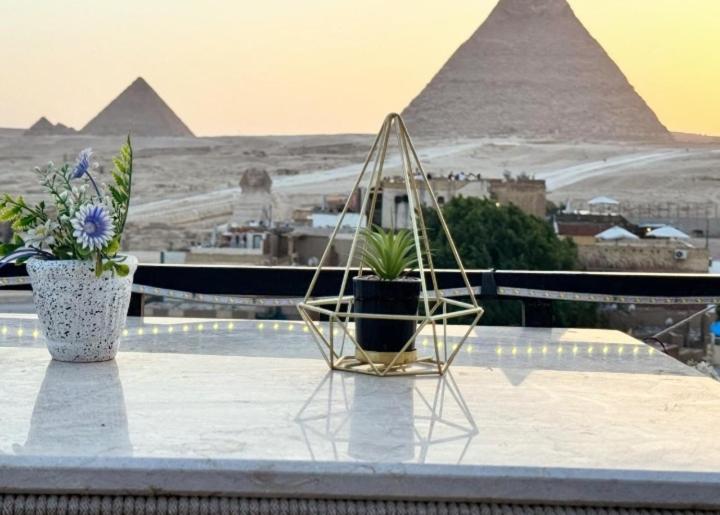 einen Stuhl auf einem Felsvorsprung mit Blick auf die Pyramiden in der Unterkunft Golden Pyramids View Inn in Kairo