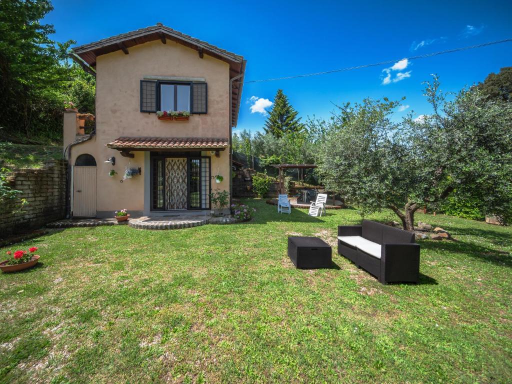 Un patio con una casa con un sofá dentro. en il lago, en Bracciano