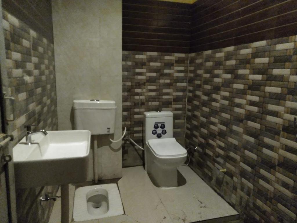 a bathroom with a toilet and a sink at Shyama Sadan in Ayodhya