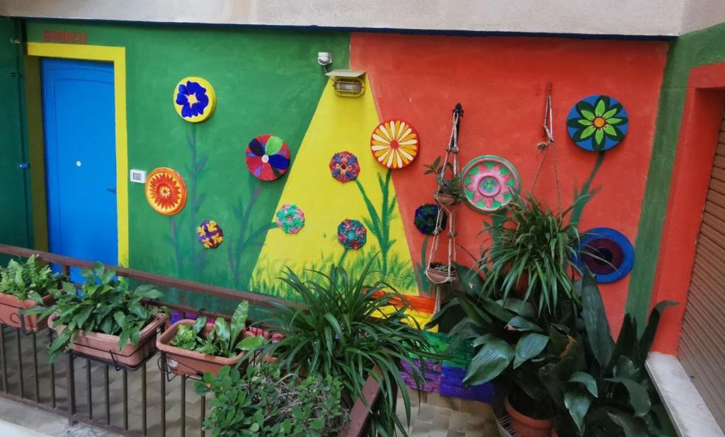 una parete colorata con piante sul balcone di Mq 36 a Marsala