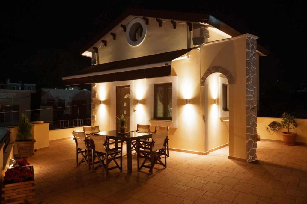 a patio with a table and chairs at night at Λειτουργικό σπίτι σε κεντρική τοποθεσία in Kalymnos