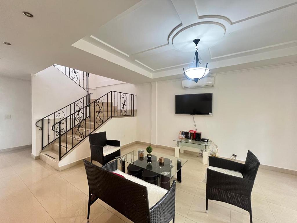 sala de estar con mesa, sillas y TV en Habitación privada en Panamá