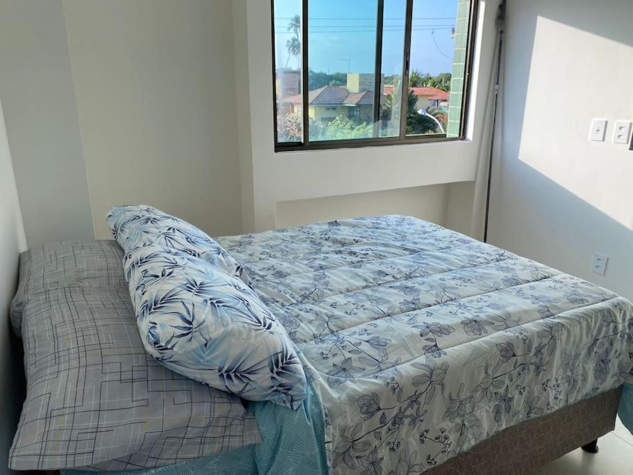 ein Bett in einem Zimmer mit Fenster in der Unterkunft Apartamento Praia do Francês in Marechal Deodoro
